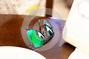 Sunglasses with colored mirrored lenses placed on the wooden table