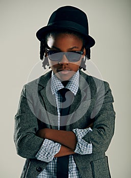 Sunglasses, fashion and kid with arms crossed in studio for stylish suit isolated on a grey background. Face, confidence