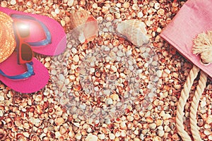 Sunglasses, flip flops sandals and a beach bag lying on the beach