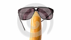 Sunglasses on a fruit head,isolated on white,funny banana with glasses,close-up.