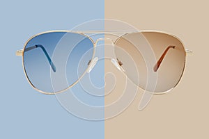 Sunglasses golden metallic frame and blue polarized lenses isolated on beige background