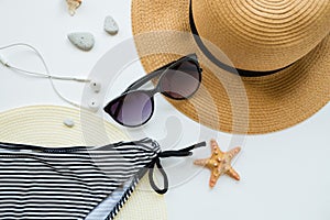 Sunglasses, hat and swimsuit on a white background. Vacation on the beach.