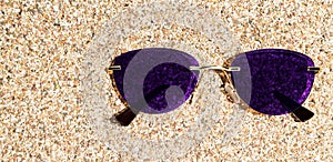 Sunglasses lie in the sand on the beach