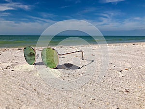 Sunglasses lying on a sandy beach getaway vacation