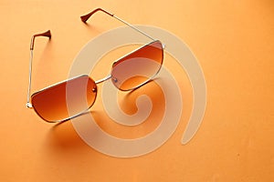 Flat lay  Square sunglasses isolate on a orange background