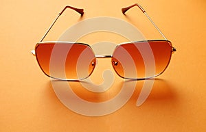 Top view  Square sunglasses isolate on a orange background