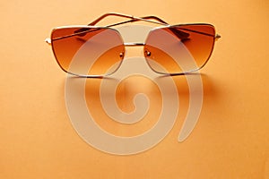 Top view  Square sunglasses isolate on a orange background