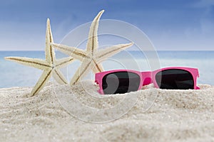 Sunglasses and sea stars at beach