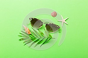 sunglasses with seashell lying on table background. Sunglasses on summer background. Top view flat lay with copy space