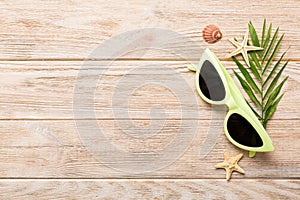 sunglasses with seashell lying on table background. Sunglasses on summer background. Top view flat lay with copy space