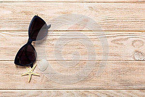 sunglasses with seashell lying on table background. Sunglasses on summer background. Top view flat lay with copy space