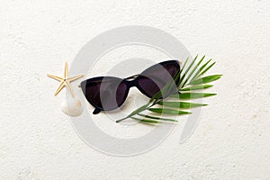 sunglasses with seashell lying on table background. Sunglasses on summer background. Top view flat lay with copy space