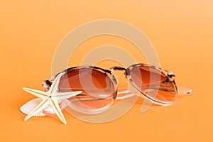 sunglasses with seashell lying on table background. Sunglasses on summer background. Top view flat lay with copy space