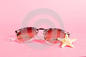 sunglasses with seashell lying on table background. Sunglasses on summer background. Top view flat lay with copy space