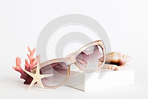 sunglasses with seashell lying on table background. Sunglasses on summer background. Top view flat lay with copy space