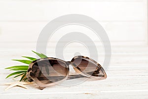 sunglasses with seashell lying on table background. Sunglasses on summer background. Top view flat lay with copy space