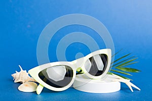 sunglasses with seashell lying on table background. Sunglasses on summer background. Top view flat lay with copy space