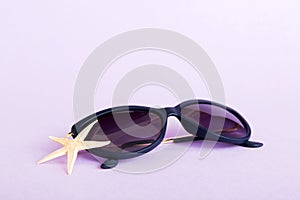 sunglasses with seashell lying on table background. Sunglasses on summer background. Top view flat lay with copy space