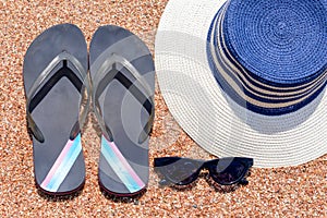 Sunglasses, Slip slops and sunhat on a tropical beach photo