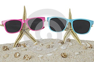 Sunglasses and starfish on beach sand