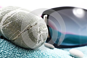 Sunglasses and stones on beach towel