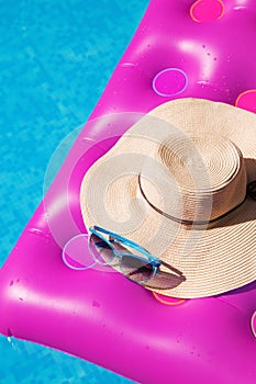 Sunglasses straw hat pink air mattress swimming pool. Tropical concept