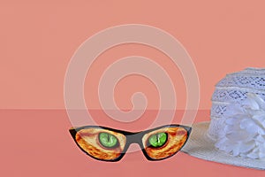 Sunglasses summer concept on pink background. Summer hat. Sunglasses reflecting cat eyes . Copy space