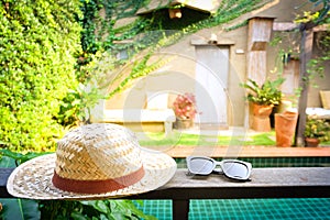 Sunglasses with vintage straw hat fasion on wooden table photo