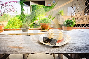 Sunglasses with vintage straw hat fasion on wooden table, Blur background for vintage resort hotel photo