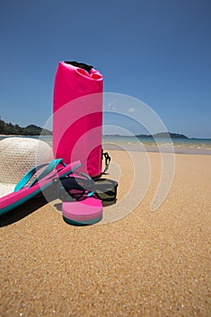 sunglasses, Waterproof bag, straw hat and flip flops on tropical