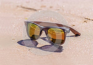 Sunglasses on wet sand, beach