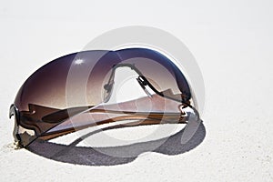 Sunglasses on white sand