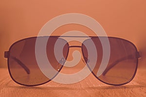 Sunglasses on a wooden background with vintage effect. Blurred background