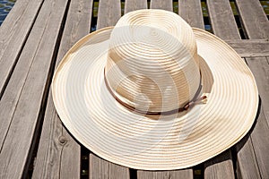 A sunhat left on a wooden dock overlooking the water