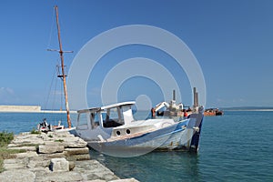 Sunk wooden boat and old rusty dredger