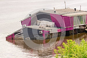 Sunken house in a river. Due to the flood, the building went under water at half the height of the wall