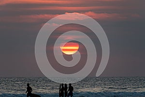 Sunkist sunset on a bali beach and kids playing photo