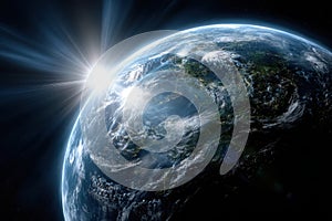 Sunlight breaking through clouds over Earth during sunrise from outer space view