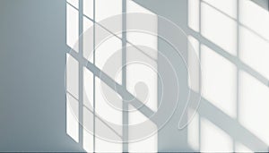 Sunlight casting geometric window shadows on white wall