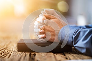 Sunlight Falling On Man's Hand Over Holy Bible