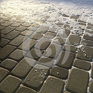 Sunlight fresh snow on the ectangle pavement