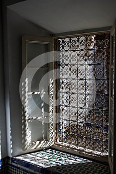 Sunlight through ornate metal window grill