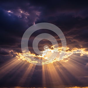 Sunlight piercing through dramatic, dense clouds creates striking rays in the sky. The
