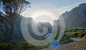 Sunlight popping over mountains at sunrise in nature in Camps Bay.