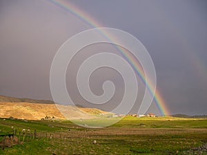 Sunlight and rain giving a bright rainbow at Westing on the island of Unst in Shetland