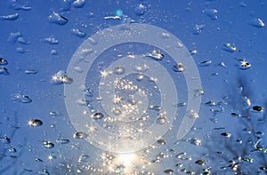 Sunlight reflections in frozen ice drops on a window