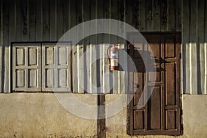 Sunlight and shadow on surface of the old wooden  window and on red wiid door on wood and cement wall background