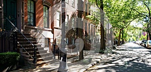 Sunlight shines on a block of historic brownstone buildings in the East Village neighborhood of Manhattan in New York City