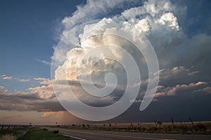 Sunlight shines on a towering cumulonimbus cloud.