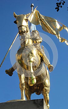 Sunlight Shining on a Gold Joan of Arc Statue
